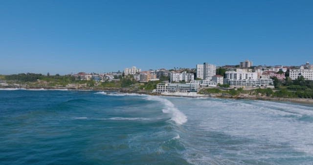 Coastal Cityscape with Waves and Clear Sky