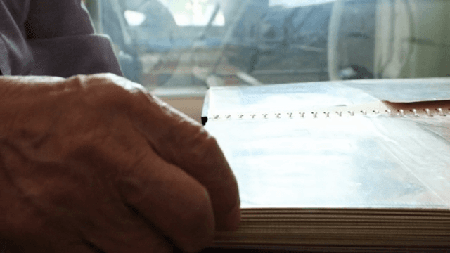 노인이 사진 앨범을 넘기는 모습