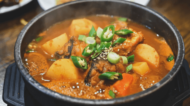 Hot bone hangover soup boiling in earthenware pot