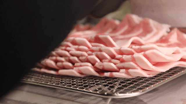 금속 선반 위에 놓인 삼겹살 돼지고기 슬라이스