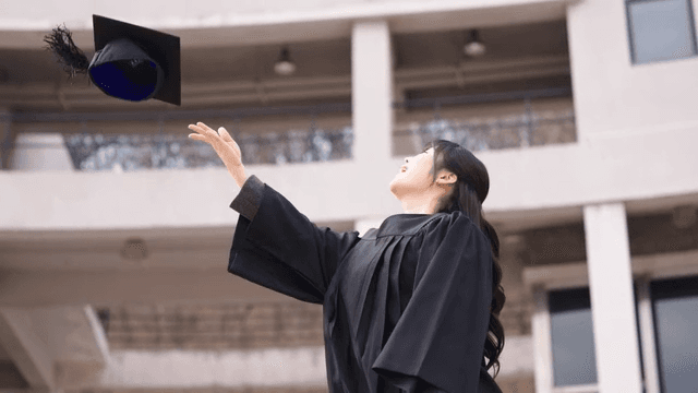 Graduates throwing their graduation caps into sky
