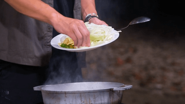 채소를 끓는 냄비에 넣는 장면