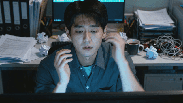 어수선한 책상에서 늦게까지 일하는 남자 회사원