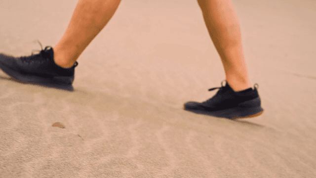 운동화를 신고 모래 위를 걷는 모습