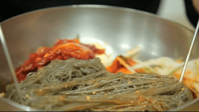 Stirring cold buckwheat noodles with raw pollack with chopsticks