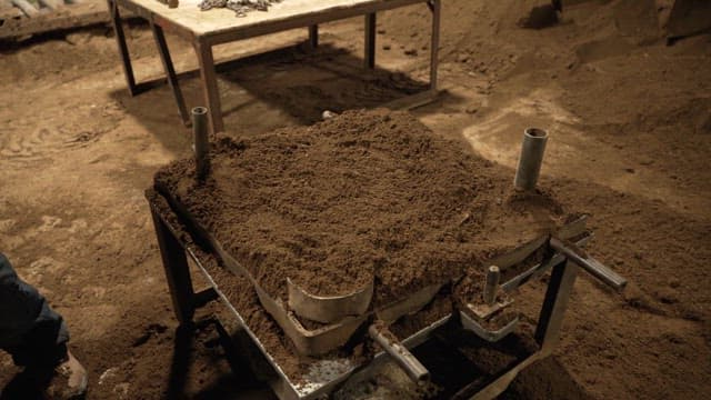 Worker preparing sand mold in a workshop