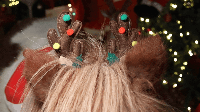 Pony wearing reindeer antler headband with Christmas lights