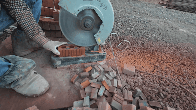 Worker cutting bricks with a saw