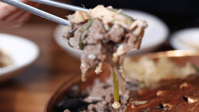 Chopsticks for scooping up bulgogi hot pot containing beef and mushrooms
