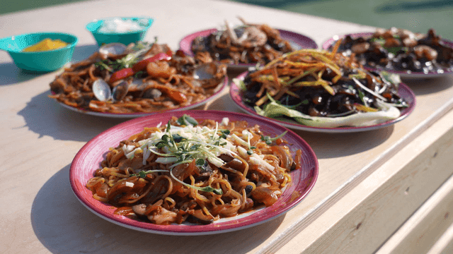 Various jajangmyeon dishes on a wooden table
