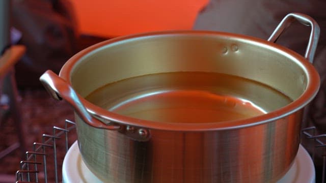 Putting ramen base into a nickel-silver pot filled with water