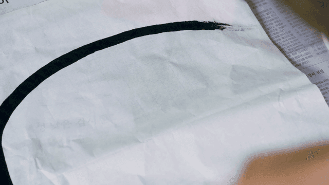 붓으로 전통 달마 그림을 그리는 사람