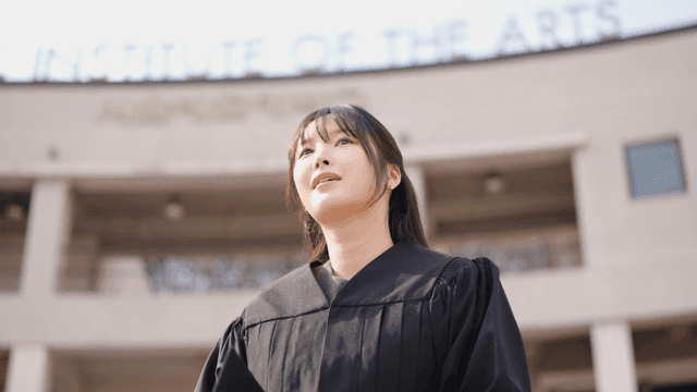 Graduate in cap and gown outside the institute