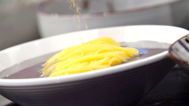검은 콩국수에 땅콩 가루를 넣는 장면
