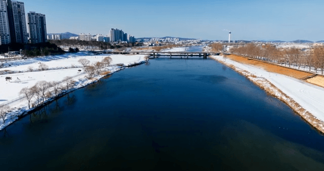 Snow-covered river and city skyline