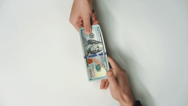 Hands exchanging currency bills