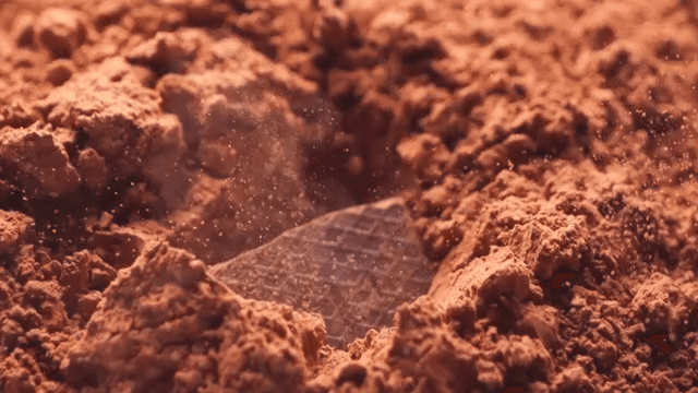 Chocolate falling onto cocoa powder in slow-motion