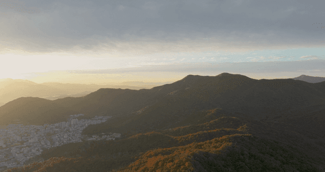 산과 도시 풍경 위로 떠오르는 일출