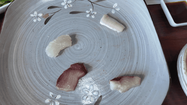 Plate with various raw fish on table