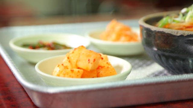 Korean food on the table with beef and rice soup on a tray