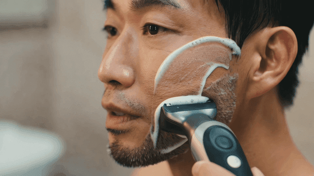 Man shaving with electric shaver