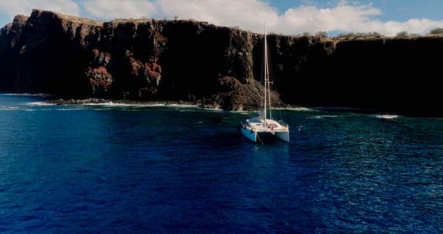 Yacht Sailing Near Rocky Cliffs