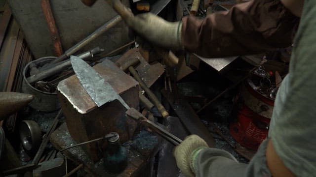 Craftsman forging a metal blade in a factory