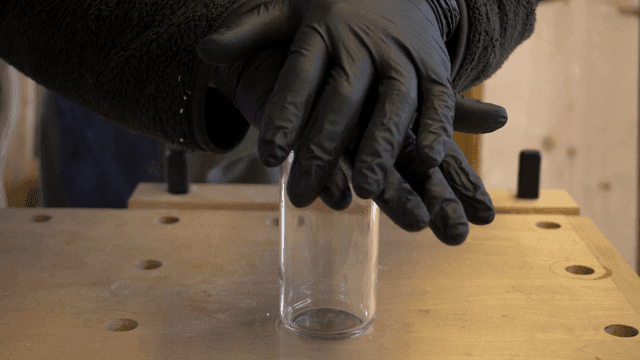 Craftsman closing and inspecting a glass jar