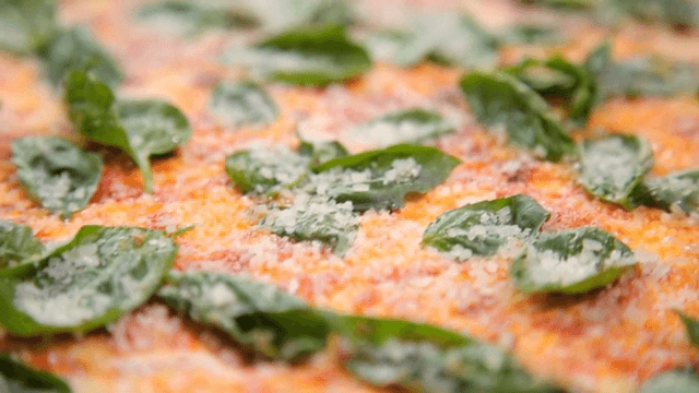 파마산 치즈가 뿌려진 바질이 올라간 피자