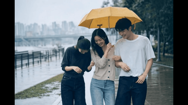 Friends walking under an umbrella on a rainy day
