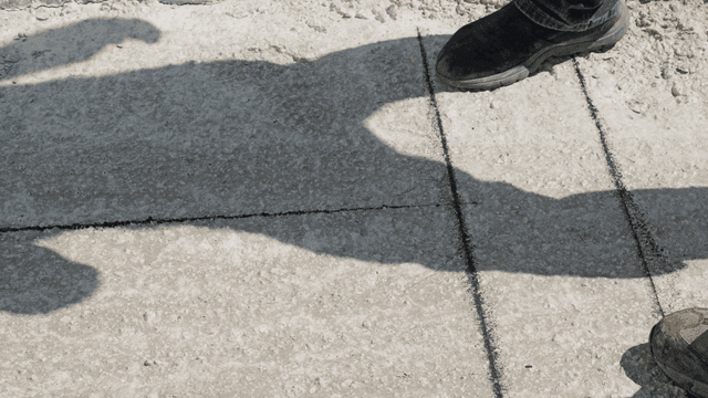 Workers measuring and marking concrete