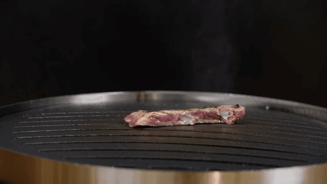 Meat grilling on a hot grill