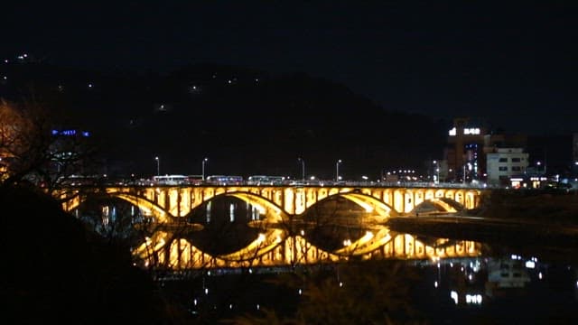 Illuminated Bridge and Traditional Architecture at Night