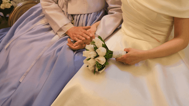 꽃을 든 신부와 어머니가 손을 잡고 있는 모습