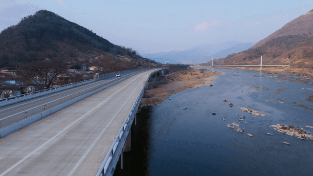 Road where cars drive on calm river