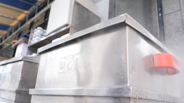 야외 시장의 금속 찜기에서 음식을 찌는 장면