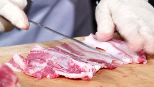 신선한 삼겹살을 썰고있는 사람