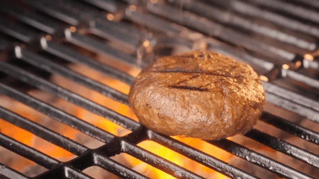 불 위에서 버거 패티를 굽는 모습