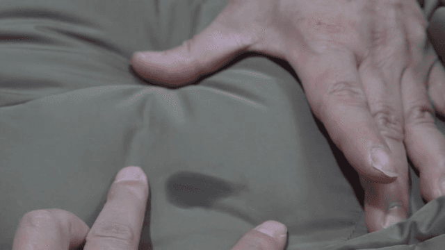 옷에 묻은 기름 얼룩을 가리키는 손가락