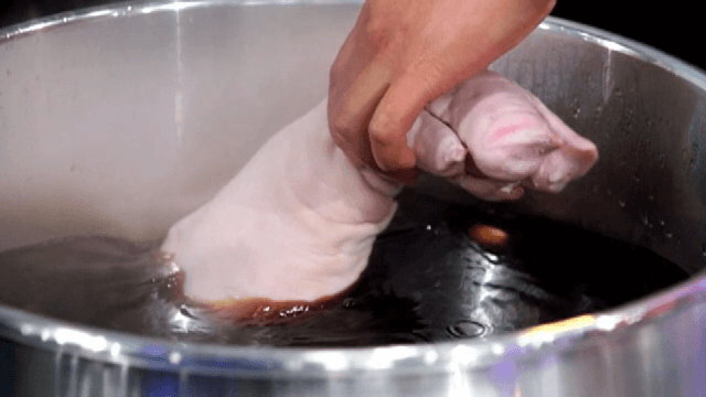 육수에 돼지 다리를 넣는 손