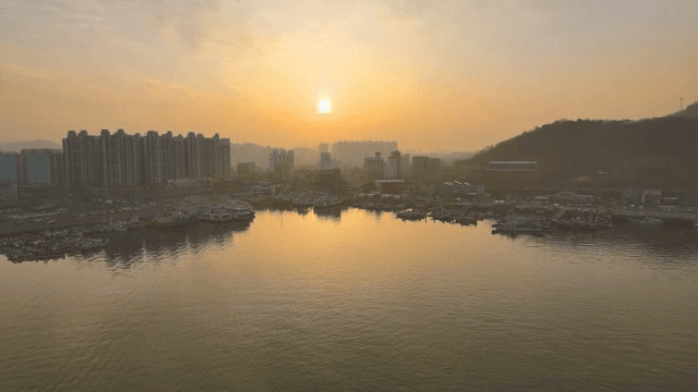 Sunset over the calm sea and city