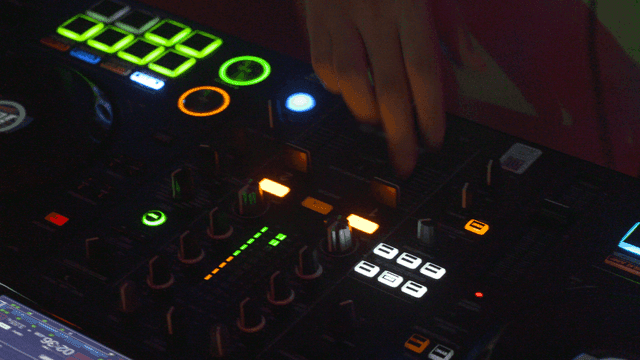DJ adjusting mixer controls