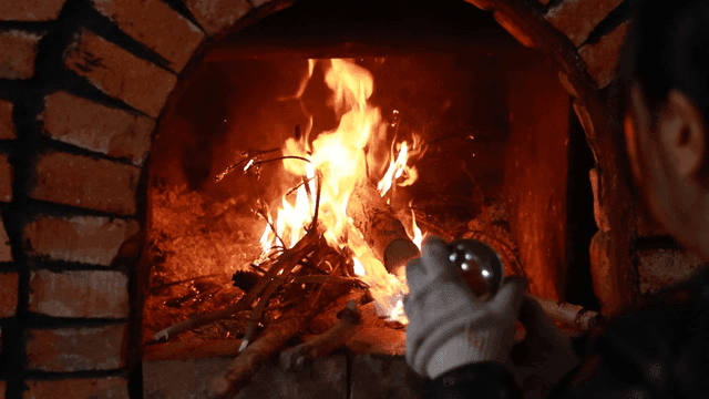Person setting fire to brick oven