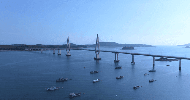 Long bridges and boats on calm sea