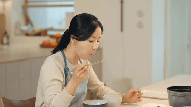Woman eating variety of side dishes at home
