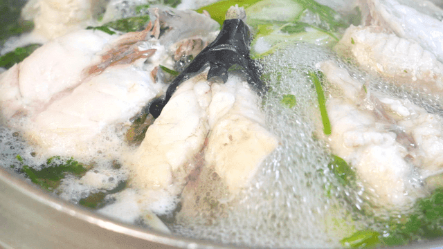 Clear pufferfish soup boiling with vegetables