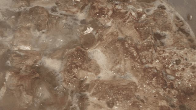 김이 나는 냄비에서 끓고 있는 고기들