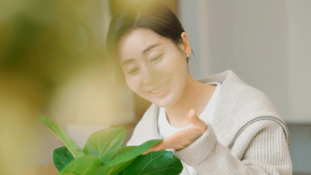 여성이 행복하게 화분을 돌보는 모습