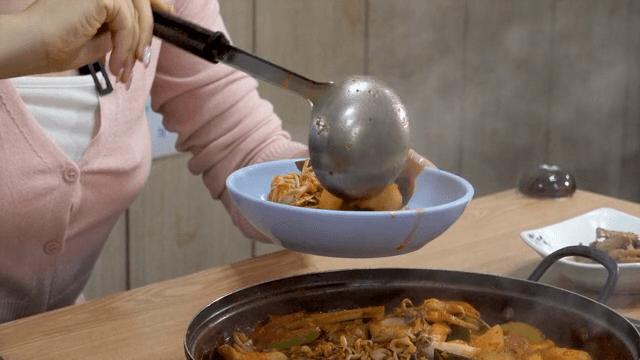 매운 한국 찌개를 그릇에 담는 모습