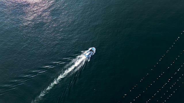 Fishing Boat Navigating Through Calm Ocean Waters